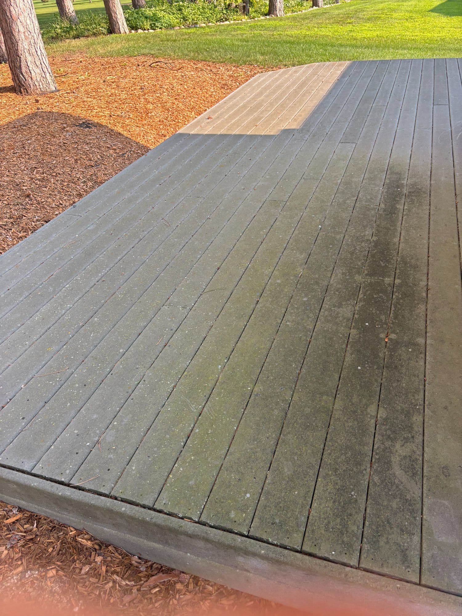 Clean vs. dirty wooden decking, showcasing maintenance difference in outdoor setting.
